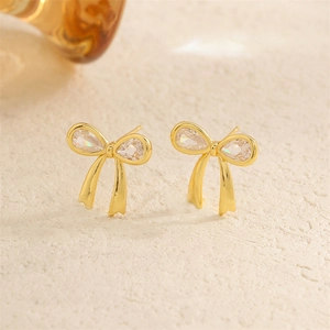 Boucles d'oreilles nœuds dorés avec zircons en forme de goutte sur socle en pierre