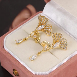 Golden ginkgo leaf drop earrings with sparkling zircon crystals in a pink jewelry box