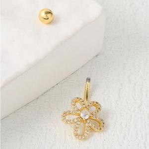 Piercing de nombril fleur en acier doré serti de zircons blancs sur marbre blanc