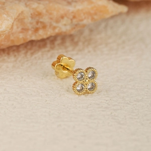Détail du piercing d'oreille trèfle doré avec zircons et fermoir à vis en forme de fleur