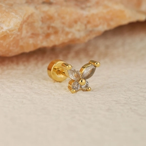 Piercing d'oreille papillon doré avec cristaux brillants sur pierre naturelle chaude