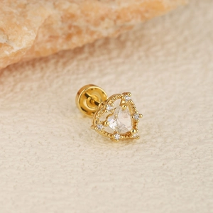 Macro view of gold heart cartilage earring with central zircon and pavé crystal accents