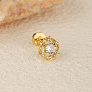 Macro view of gold flower cartilage earring with crystal center and screw back