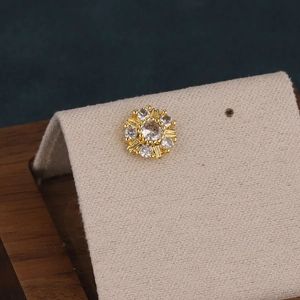 Macro shot of gold sun flower cartilage stud earring with sparkling cubic zirconia