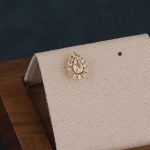 Close-up of a gold-plated teardrop stud earring with micro-pave pear-cut crystals