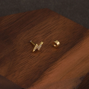 Détail d'un piercing hélix éclair en or serti de zircons brillants et fermoir à vis