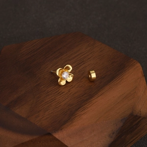 Macro view of gold flower cartilage earring with cubic zirconia and screw ball back