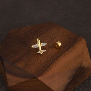 Detail view of a gold-plated airplane cartilage stud earring with cubic zirconia crystals