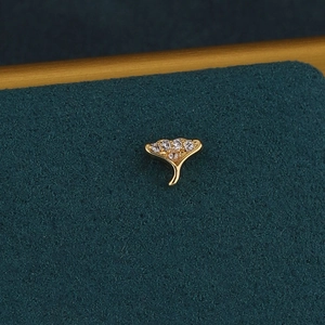 Vue macro de la puce d'oreille feuille de ginkgo dorée avec cinq zircons étincelants