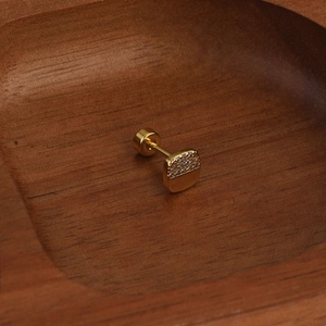 Vue macro détaillée du clou d'oreille doré avec pavé de cristaux et fermoir plat à vis