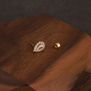 Detail view of gold flower cartilage stud with teardrop crystal and screw back ball
