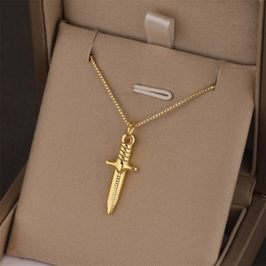 Minimalist gold dagger pendant necklace with box chain displayed in a gift box