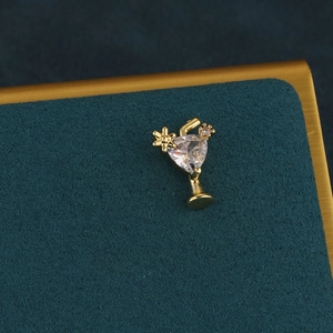 Macro view of gold cocktail glass earring with triangle cubic zirconia and flower detail
