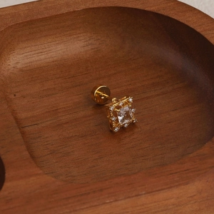 Macro detail of a 18K gold square zircon earring featuring a secure screw-back flat design