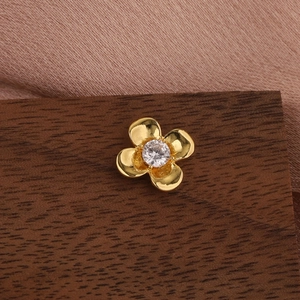 Macro view of gold-plated flower stud earring featuring a central sparkling zircon inlay