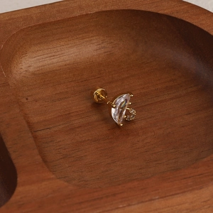 Close-up of gold flower cartilage earring with pear-cut stone and screw-back detail