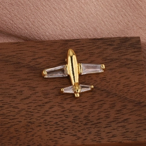 Detailed 45-degree view of a golden airplane brooch with clear zircon stone inlay