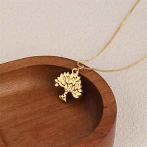 Golden Tree of Life pendant necklace in 18K gold-plated stainless steel on a wooden tray