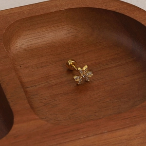 Detailed view of flower cartilage earring with cubic zirconia and screw-back in gold finish