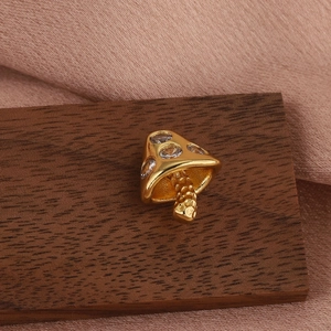 Macro shot of gold mushroom cartilage piercing earring with sparkling zircons on wood