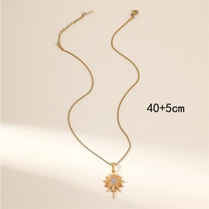 Gold starburst pendant necklace with white crystals on a dainty adjustable chain