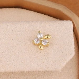 Macro detail of 18K gold plated clover stud earring set with three round cubic zirconia stones