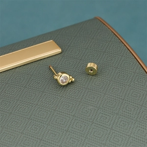 Macro detail of star zircon earring in 18K gold plating with matching secure round back