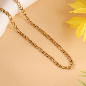 Macro detail of 18K gold Figaro chain link texture with polished stainless steel finish