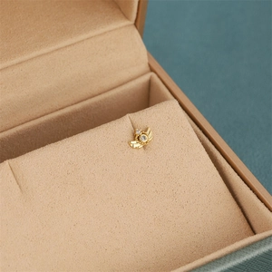 Macro shot of 18K gold plated earring with zircons on a velvet jewelry display tray