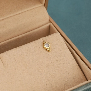 Detailed macro view of 18K gold-plated stud earring with zircon inlay in a velvet box