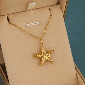 Minimalist gold hollow starfish pendant necklace with hammered texture in jewelry box