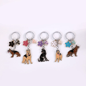 Detailset aus fünf Schäferhund-Schlüsselanhängern aus Metall mit bunten Emailleblumen