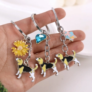 Detailed view of three enamel beagle dog keychains with colorful floral and heart charms