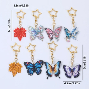 Set of acrylic butterfly and maple leaf keychains with gold star-shaped clips