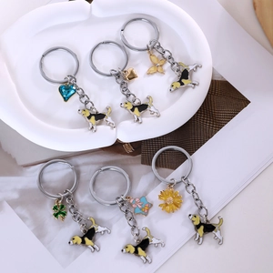 Detail view of cartoon Foxhound dog enamel keychains with various crystal charms and daisies