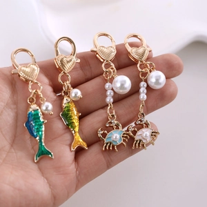 Pendentifs poisson et crabe dorés avec fermoir coeur, émail et perles blanches