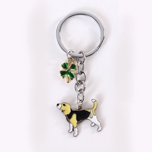 Detailed view of foxhound dog pendant and lucky green clover metal keychain for bags