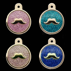 Close-up of circular pet ID tags with glitter finish and golden mustache design