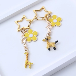 Cute giraffe keychain with star and flower charms on a white minimalist tray