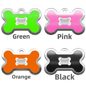 Detail view of bone-shaped pet ID tags in green, pink, orange, and black metal finish