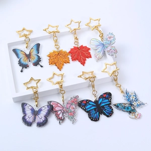 Détail macro de porte-clés papillon en acrylique avec clips métalliques dorés en étoile