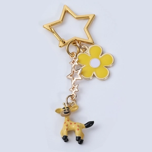 Detailed close-up of a golden giraffe keychain with enamel flower and star charms