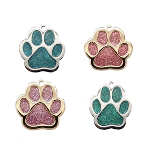 Macro detail of glitter paw-shaped pet ID tags with colorful enamel in four vibrant colors