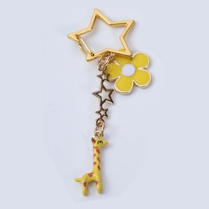 Detail view of cartoon giraffe keychain with star clasp and yellow enamel flower pendant