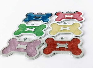 Macro shot of glitter-filled bone-shaped pet tags in six vibrant colors with metallic edges