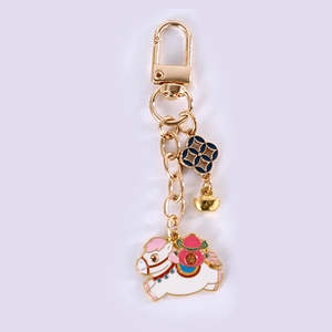 Detail of white zodiac horse keychain with red gourd and golden ingot charm