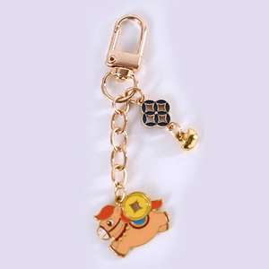 Detail of running pony keychain with gold ingot and coin charms for bag decoration