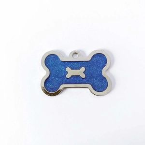Detail of bone-shaped pet tag with blue glitter finish and silver bone inlay decoration
