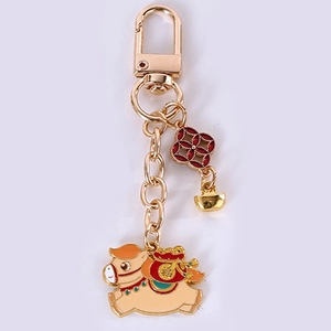 Detail of golden zodiac horse keychain with red money bag and Chinese Fu character