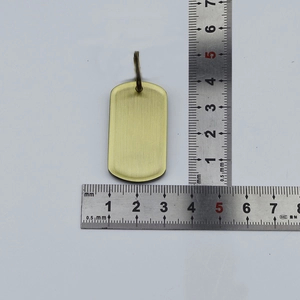 Brushed gold stainless steel pet tag pendant measuring 50mm by 28mm on a grey background